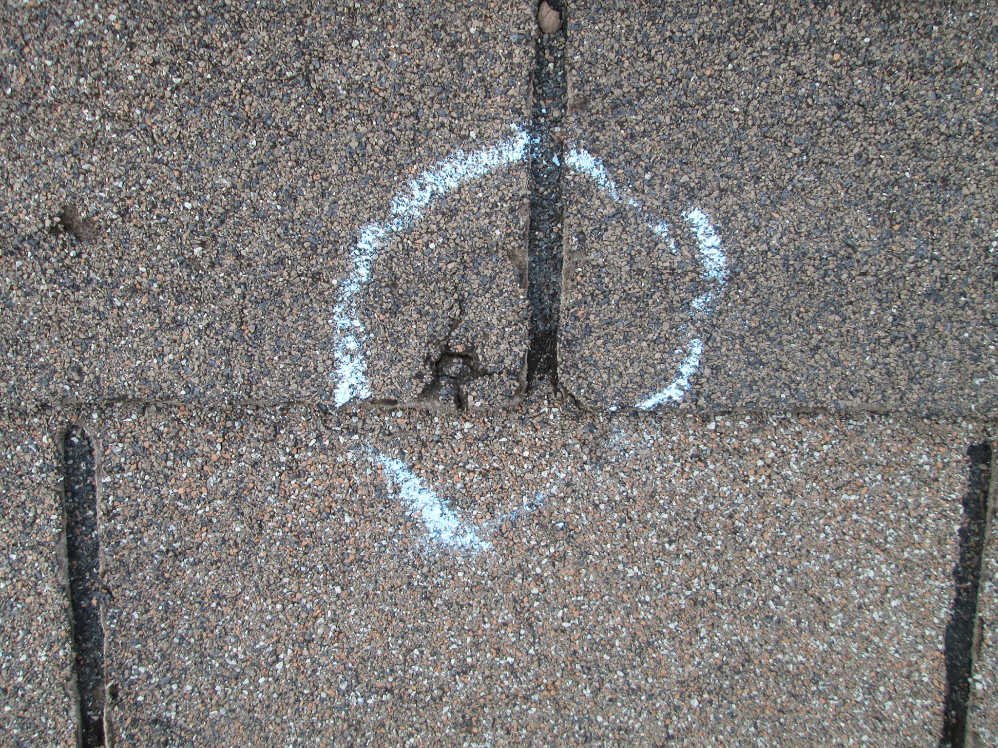 Hail damage marked on shingles during inspection
